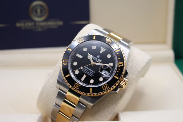 Rolex Submariner laid backwards with the light reflecting on its dial