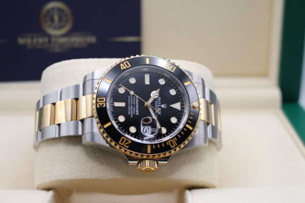 Rolex Submariner bi-metal black dial laid on its side on a watch cushion