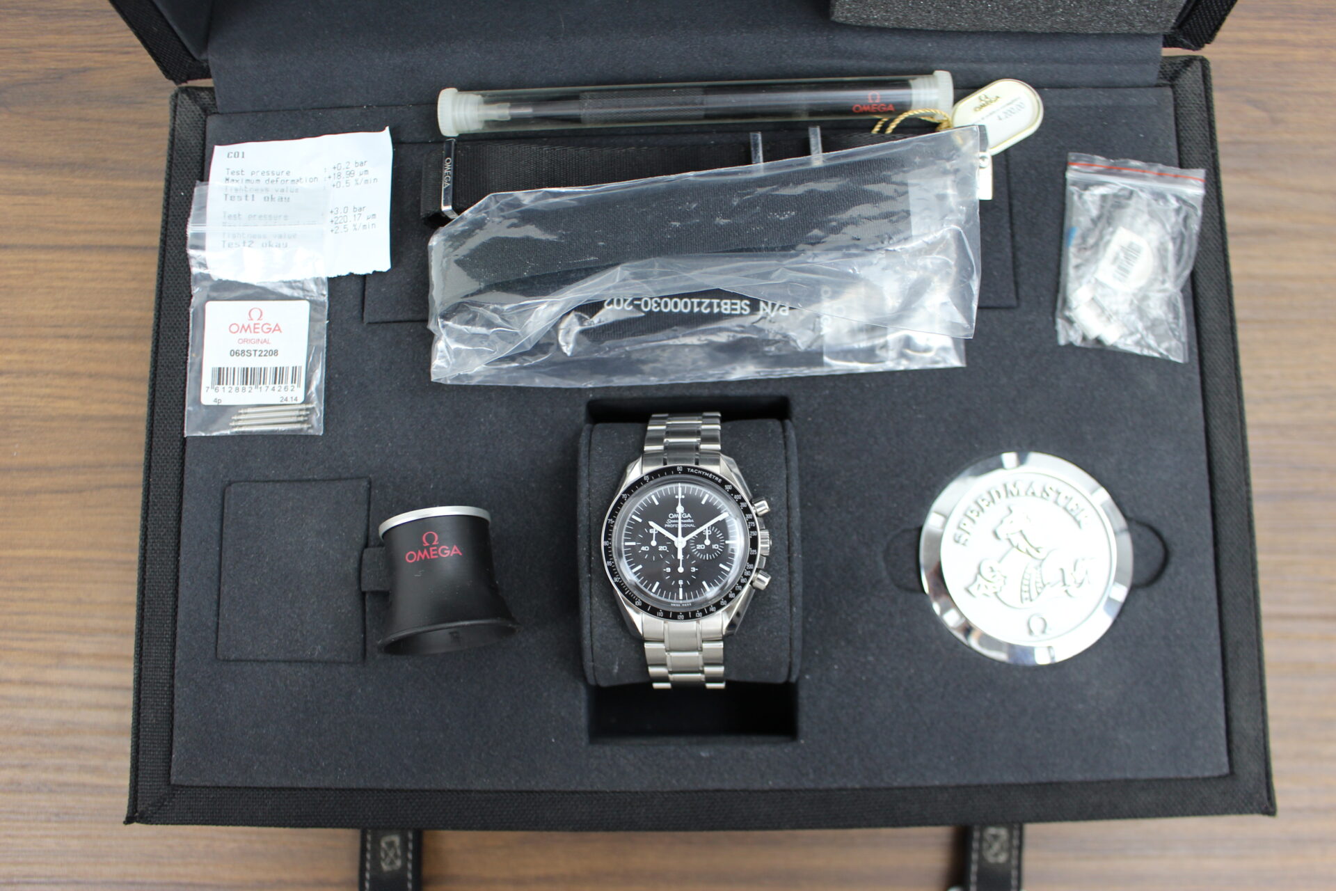 Omega Speedmaster Moonwatch Professional in it's box with Omega paperweight, magnifying loupe, spring bar tool, 2x additional straps, swing tag