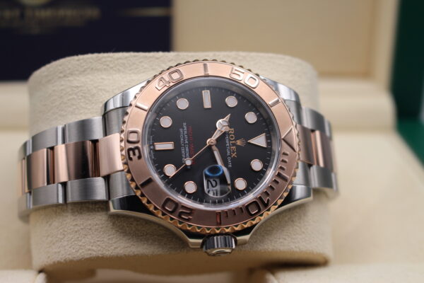 Rolex Bi-Metal Yacht-Master 40mm with a black dial laid on its side on a watch cushion