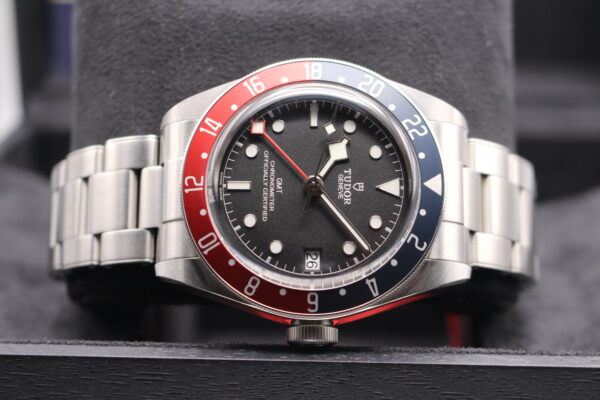Tudor GMT Pepsi laid on side side with a black dial and blue and red bezel