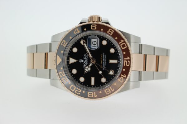 Rolex GMT Master II Rootbeer laid on its side on a white background
