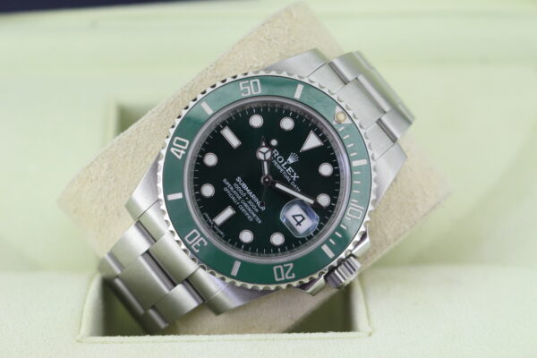 Rolex Green Submariner leaned to one side with light reflecting on the dial