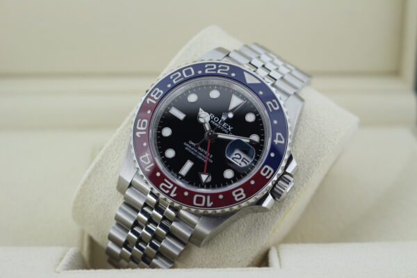 Rolex GMT Pepsi watch with a blue and red bezel leaned at an angle