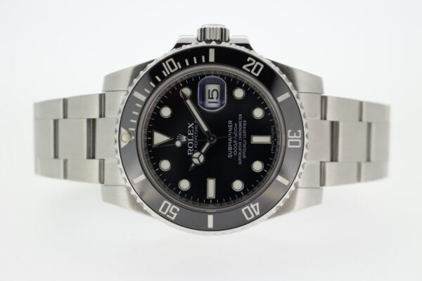 Rolex Submariner laid on its side on a white background