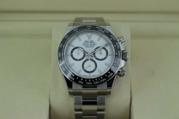 Rolex Daytona 'Panda' 126500 in it's box tilted up showing a black bezel, white dial and three black sub dials. The watch has an Oyster bracelet.