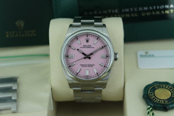 Rolex Oyster Perpetual 36 126000 with pink dial close up of watch in it's box with both green and white swing tags and spare links, booklets and warranty cards