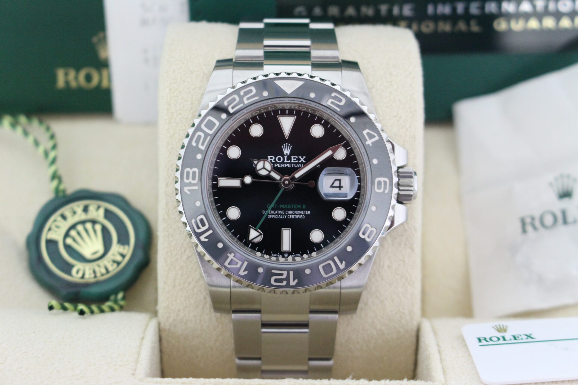 Close up of Rolex GMT Master II Bruce Wayne 126710GRNR in it's box with booklets, both swings and warranty card