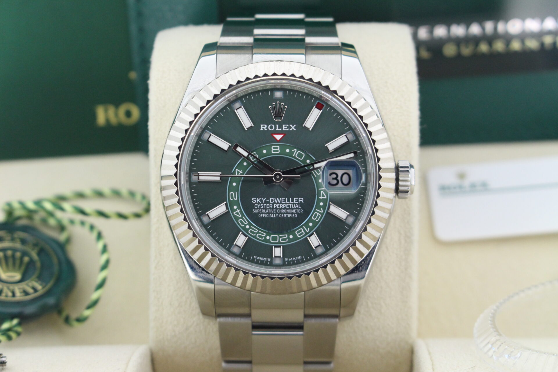 Close up of Rolex Sky-dweller 336934 Green Dial in it's box with booklets, warranty cards and both swing tags
