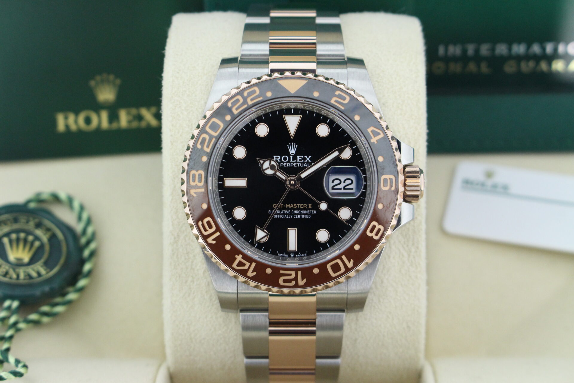 Close up of Rolex GMT Master II Rootbeer 126711CHNR in it's bow with both swing tags, booklets and warranty card