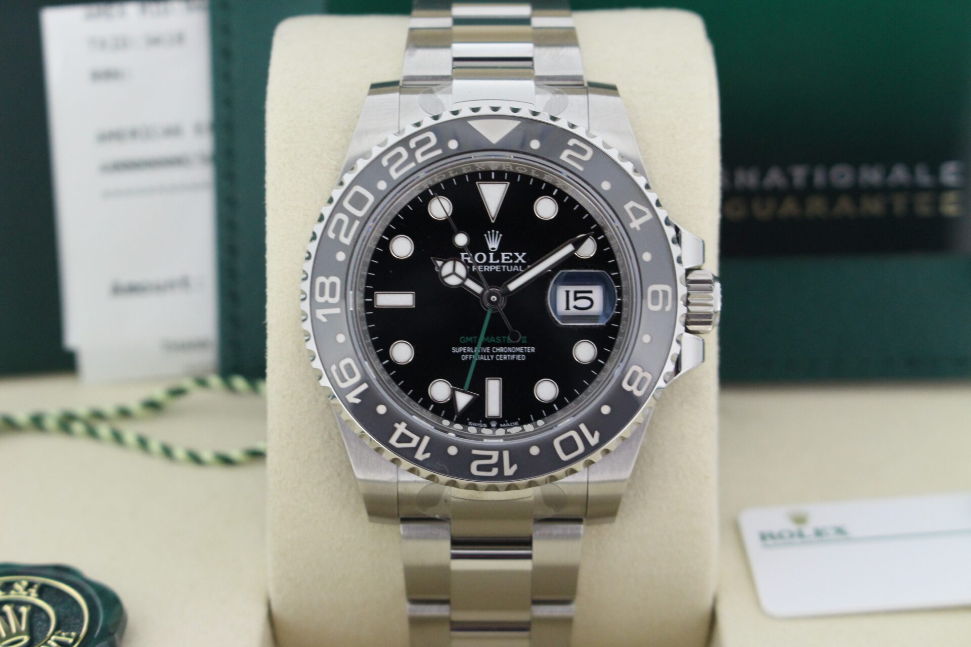 Close up of Rolex GMT Master II Bruce Wayne 126710GRNR in it's box with both swing tags, booklets and warranty card