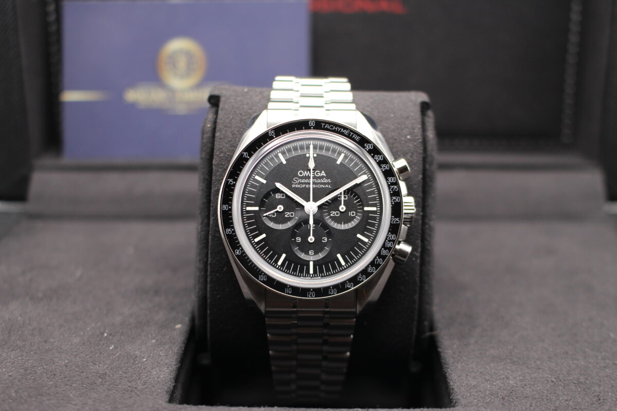 Omega Speedmaster sat in the upright position on a watch cushion inside of its box