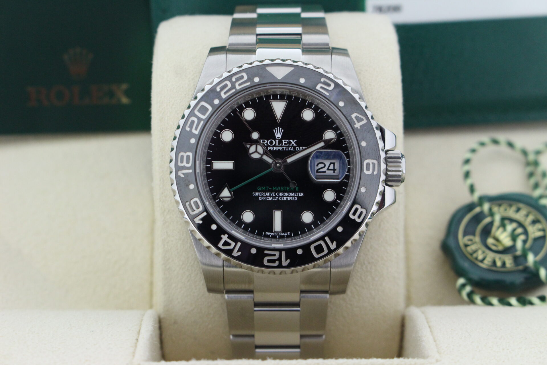Close up of Rolex GMT Master II Black 116710LN in it's box with green swing tags, booklets and warranty card dated October 2015