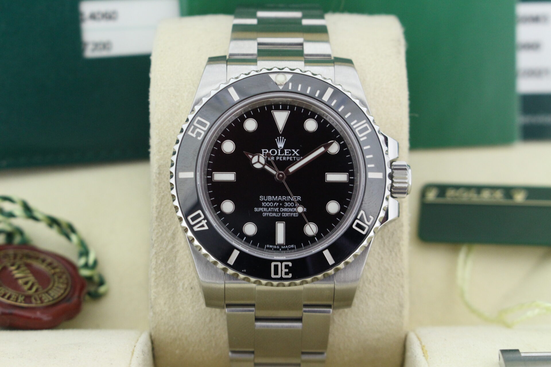Close up of Rolex Submariner No Date 114060 in it's box with both swing tags, booklets and warranty card