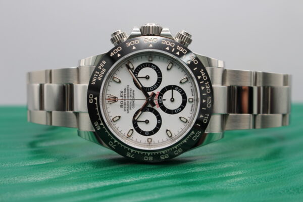 Rolex Daytona on its side on top of a green wave Rolex box