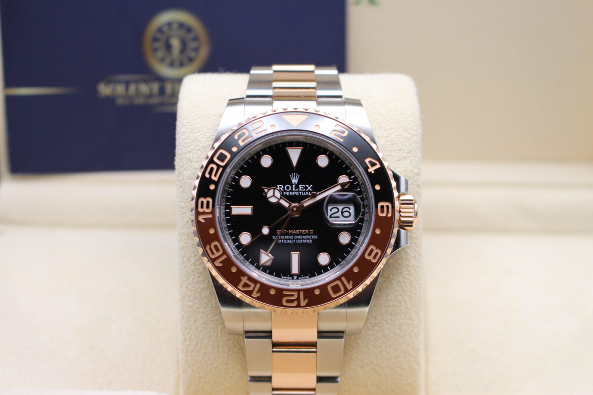 Rolex GMT Master II Rootbeer on display on its watch cushion reading 10 past 10