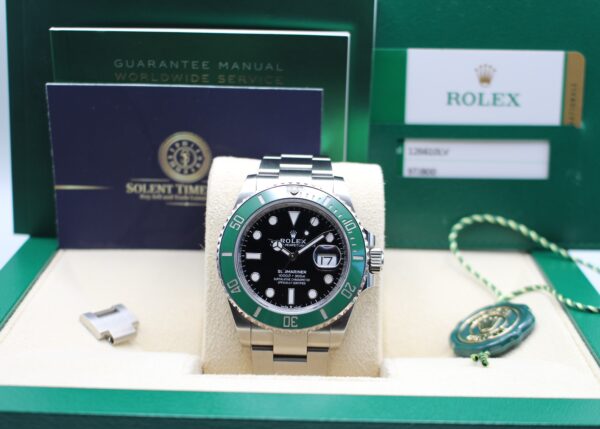 Rolex Submariner with a green bezel on display as a full set with all its original accessories