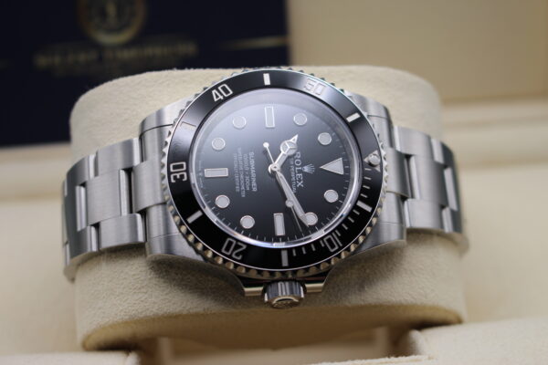 Rolex submariner laid on its side with light reflecting on the dial