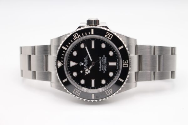 Rolex Submariner displayed on a white background laid on its side