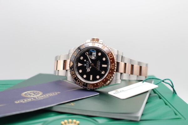 Rolex Rootbeer laid on its side on top of its box, creating a lifestyle photo