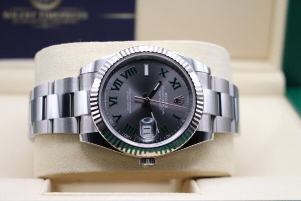 Rolex Datejust 41m with a white gold fluted bezel laid on its side on the watch cushion