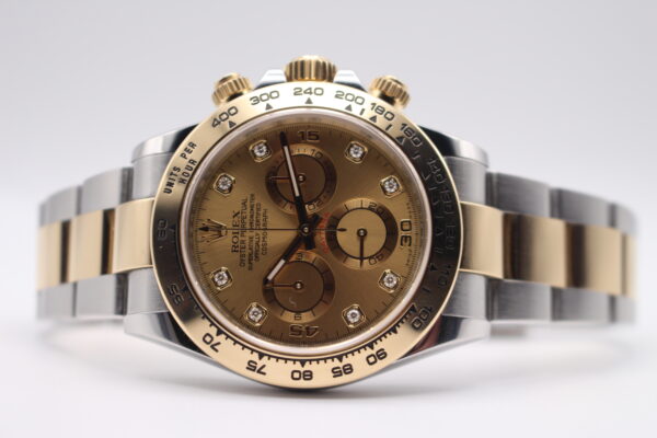 Rolex Daytona laid on its side crown facing up on a white background