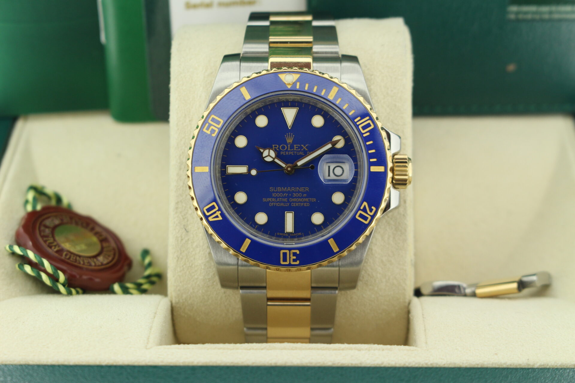 Close up of Rolex Submariner Bluesy 40mm 116613LB in it's box with red swing tags, booklets and warranty card