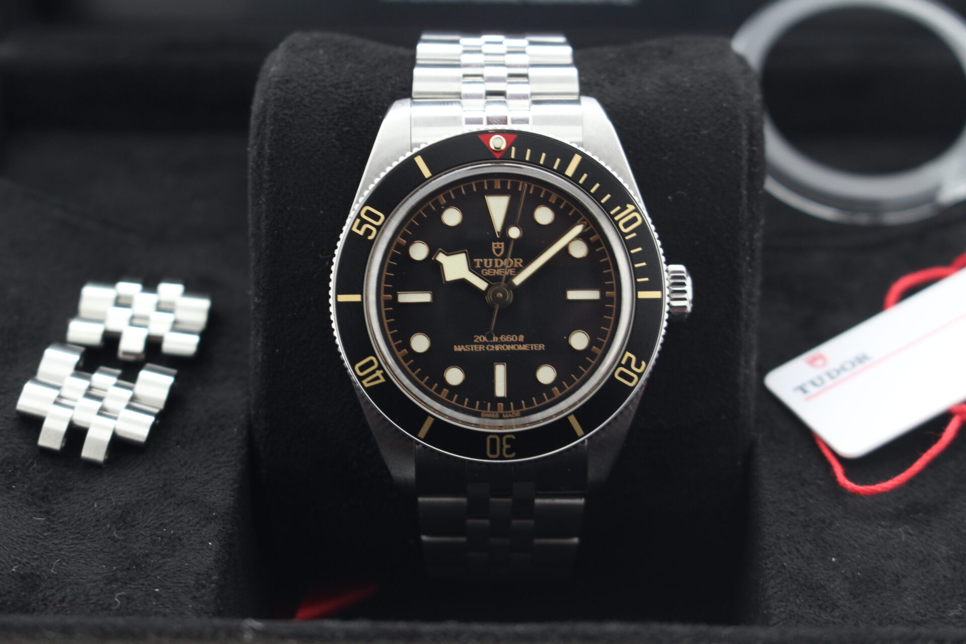 Close up of Tudor Black Bay 58 7939A1A0NU in it's box witth swing tags, bezel protector, links, booklet and warranty card