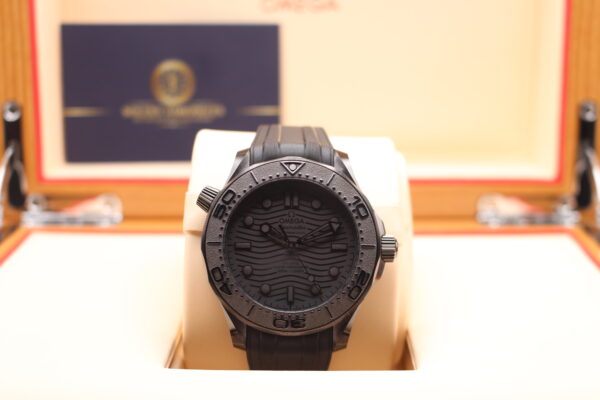 Omega Seamaster ceramic watch in its box with business card behind