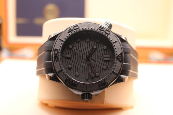 Black Ceramic Omega Seamaster on its watch cushion laid on its side