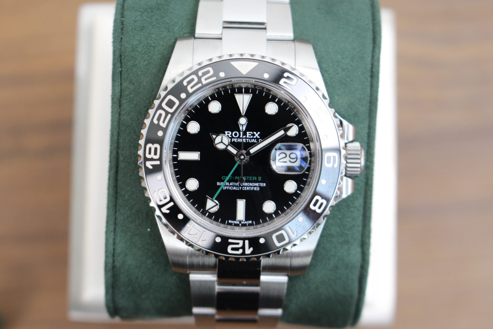 Rolex GMT Master II 116710LN on a green cushion